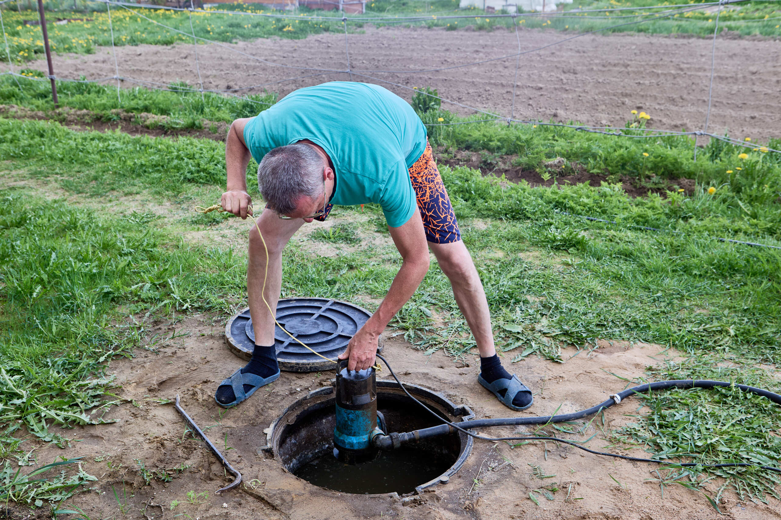 Instalação de bomba submersa em poço artesiano em área rural, utilizada para captação de água e abastecimento de residências e propriedades.